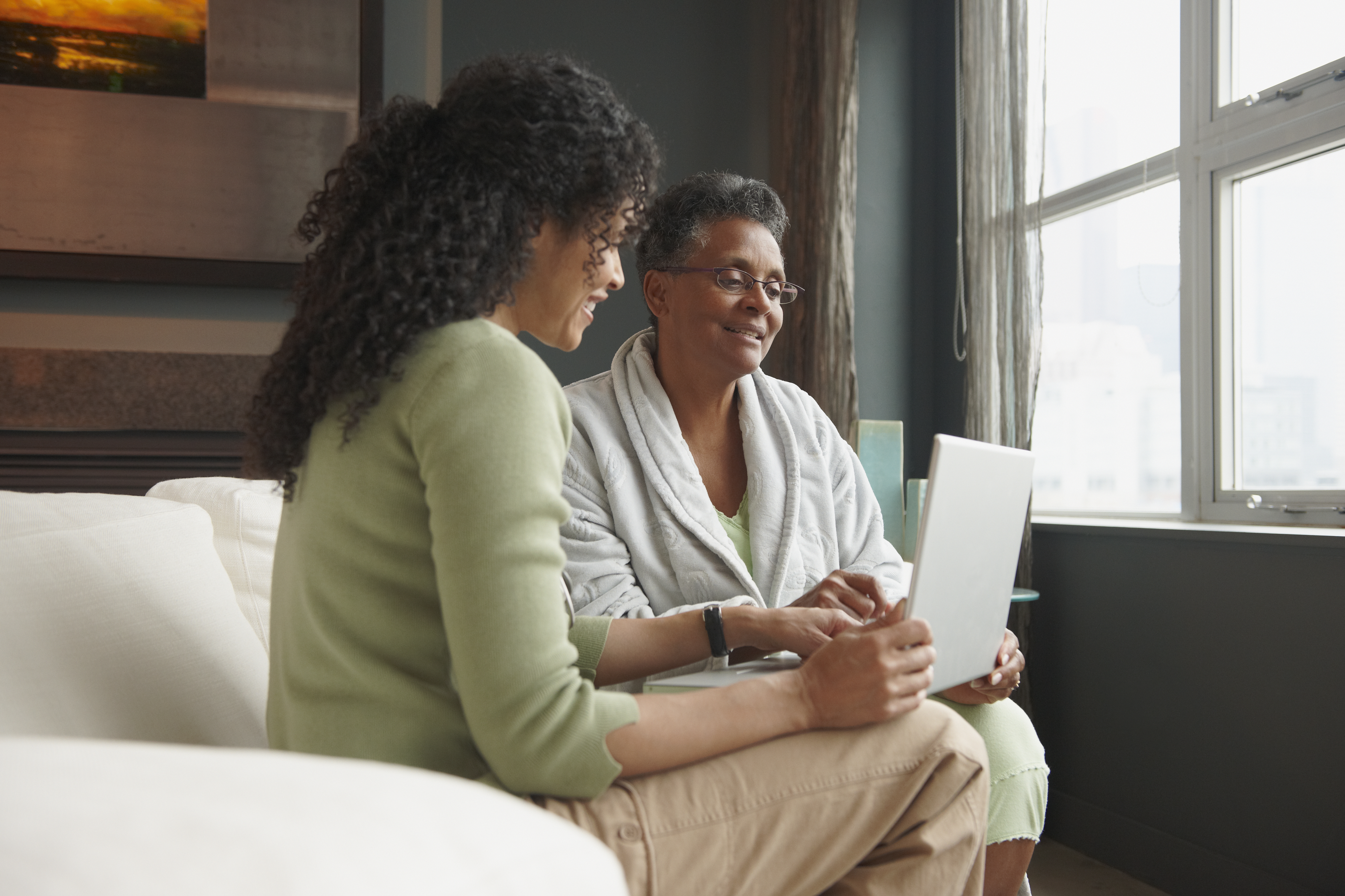 woman helping older woman with computer